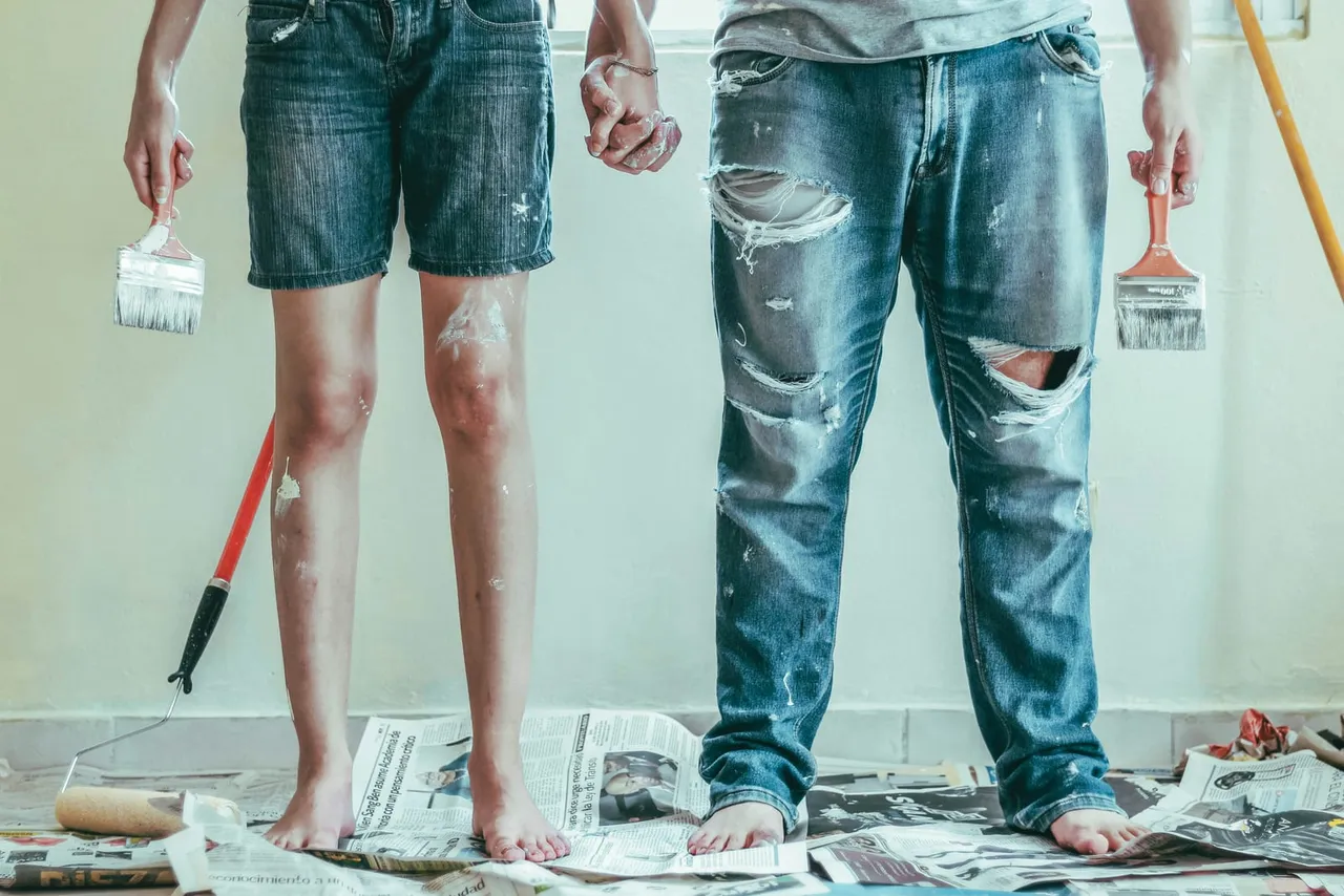 Two people doing DIY home painting with brushes representing the build-it-yourself approach to CSPM versus IOmergent managed services.